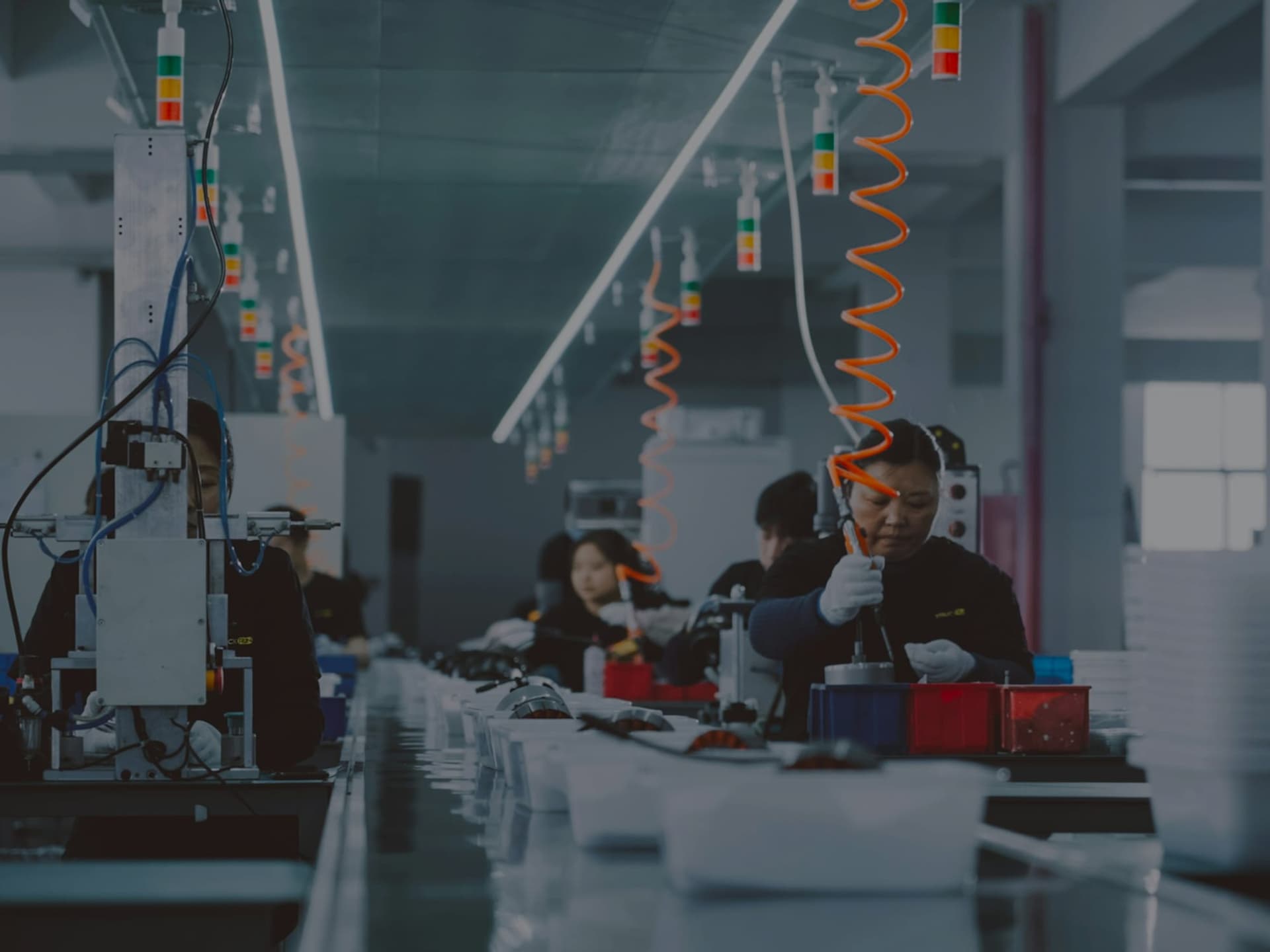 Montagelinje med medarbejdere ved stationerne og andonsøjler over båndet